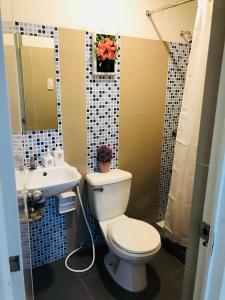 a bathroom with a toilet and a sink at Contemporary cozy 6- 2BR Apartment in Davao City
