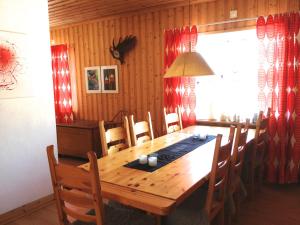 una sala da pranzo con tavolo e sedie in legno di Stora Björnstugan a Laisvall Altre 37 foto