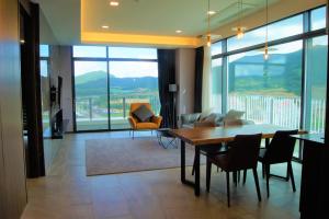 - un salon avec une table, des chaises et une grande fenêtre dans l'établissement AM Hotel, à Pyeongchang