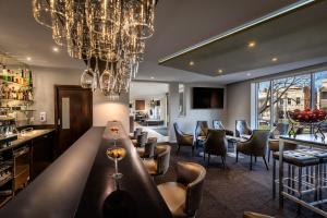 a restaurant with a bar with chandeliers at BEST WESTERN PLUS Travel Inn in Melbourne