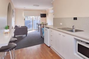 a kitchen with a stove a sink and a refrigerator at Elphin Serviced Apartments in Launceston