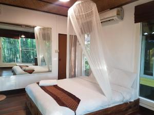 a bedroom with a bed with mosquito netting at Chang Pai Garden in Pai