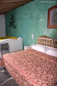 a bedroom with a large bed and a tv at Posada de la Mision, Hotel Museo y Jardin in Taxco de Alarcón