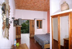 a bedroom with a bed in a room with a window at Posada de la Mision, Hotel Museo y Jardin in Taxco de Alarcón
