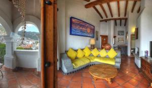a living room with a couch with yellow pillows at Posada de la Mision, Hotel Museo y Jardin in Taxco de Alarcón