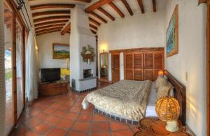 a bedroom with a bed and a television in it at Posada de la Mision, Hotel Museo y Jardin in Taxco de Alarcón
