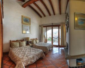 a bedroom with two beds and a balcony at Posada de la Mision, Hotel Museo y Jardin in Taxco de Alarcón