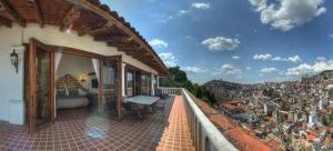 a balcony of a building with a view of a city at Posada de la Mision, Hotel Museo y Jardin in Taxco de Alarcón