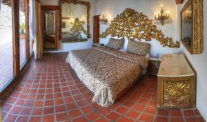 a bedroom with a large bed and a mirror at Posada de la Mision, Hotel Museo y Jardin in Taxco de Alarcón