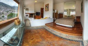 a bedroom with a bed and a large window at Posada de la Mision, Hotel Museo y Jardin in Taxco de Alarcón