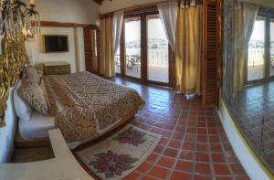 a bedroom with a bed in a room with windows at Posada de la Mision, Hotel Museo y Jardin in Taxco de Alarcón