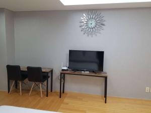 a room with a television and a table with chairs at Sky Guestel in Incheon