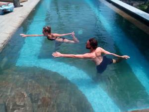 twee mensen in het water in een zwembad bij Pebble & Fins Bali Dive Resort in Tulamben