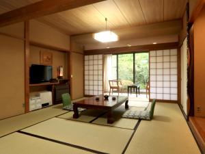 una sala de estar japonesa con mesa y sillas en Mitake, en Hakone