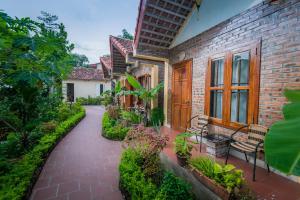 een stenen loopbrug naast een huis met een bank bij Tam Coc Lake View Homestay in Ninh Binh