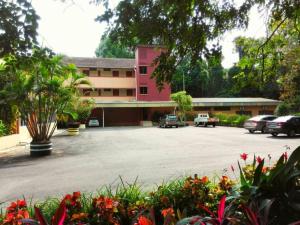 un parcheggio di fronte a un edificio rosa di Mersing Merlin Inn a Mersing