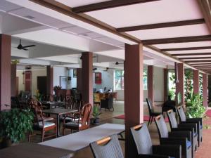 una sala da pranzo con tavoli, sedie e una tavola di Mersing Merlin Inn a Mersing