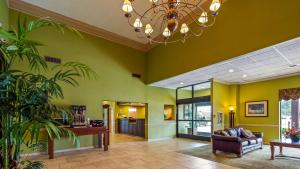 uma sala de estar com paredes verdes e um lustre em Best Western Shepherdsville em Shepherdsville