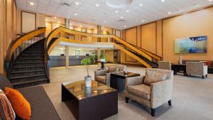 a lobby with a staircase with chairs and a table at Best Western North Bay Hotel & Conference Centre in North Bay