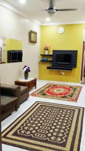 a living room with a couch and a rug at KhainadzMuslim Homestay in Melaka