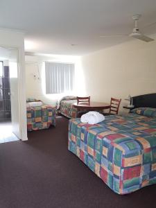 um quarto de hotel com duas camas e uma mesa em Harbour Lodge Motel em Gladstone