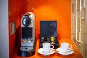 ウィーンにあるブティックホテル ダス チロルの- パソコン、コーヒー2杯(テーブル上)