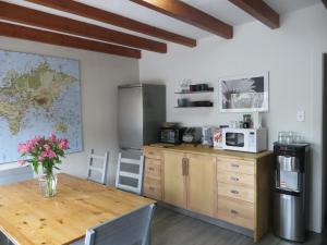 a kitchen with a table with a vase of flowers on it at At Wits End B&B in Banff