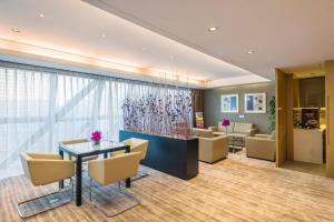 a lobby of a hotel with a table and chairs at Ascott Raffles City Beijing in Beijing