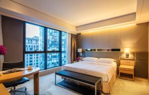 a hotel room with a bed and a desk and a window at Ascott Raffles City Beijing in Beijing