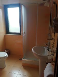 a bathroom with a shower and a sink and a toilet at Hotel Del Sole in Pastorano