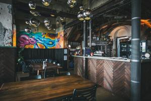 a bar with a wooden table and a colorful wall at Six Degrees Motel in Albany