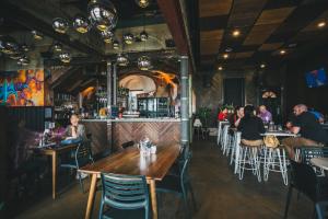 a restaurant with people sitting at tables and a bar at Six Degrees Motel in Albany