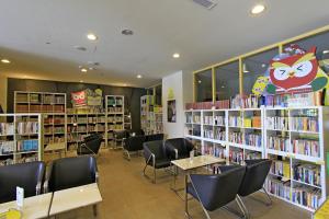 biblioteka ze stołami, krzesłami i półkami na książki w obiekcie Lishan Guest House w mieście Heping