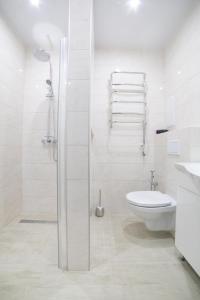 Un baño blanco con ducha y WC. en Elegant VIP apartment, en Sumy
