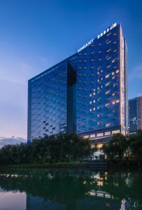 un gran edificio con un reflejo en una masa de agua en Somerset Swan Lake Hefei, en Hefei