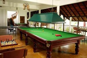 a pool table in a living room with a pool at Punnamada Resort in Alleppey