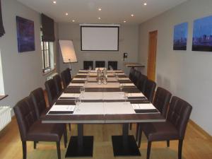 una gran sala de conferencias con una mesa larga con sillas en Hotel Klein Nederlo en Vlezenbeek