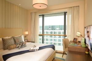 a bedroom with a bed and a desk and a large window at Somerset Software Park Xiamen in Xiamen +40 photos