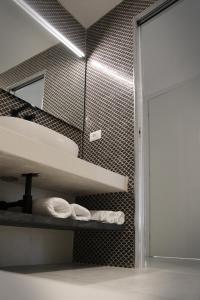 a bathroom with a shelf with towels and a mirror at MADA Charm Apartments Terrace&Carugio in Vernazza