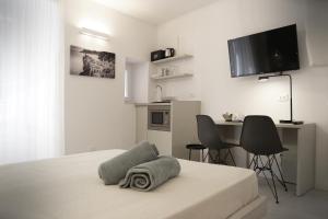 a white bedroom with a bed with a towel on it at MADA Charm Apartments Terrace&Carugio in Vernazza
