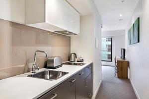 a kitchen with a sink and a refrigerator at Seasons Heritage Melbourne in Melbourne
