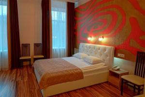 1 dormitorio con 1 cama y una pintura en la pared en Aragon Hotel, en Riazán