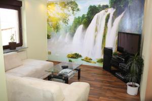a living room with a large waterfall mural on the wall at Ferienwohnung Golden Lotus in Neuwied