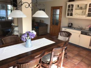 a kitchen with a table with a vase of flowers on it at "Leuchtturmhaus" by Ferienhaus Strandgut in Born