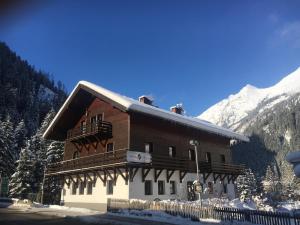 ein großes Holzgebäude mit Balkon im Schnee in der Unterkunft Ski Lodge Jaktman in Bad Gastein