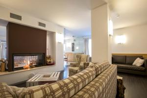 a living room with a couch and a fireplace at Hotel Luna Bianca Folgaria in Folgaria
