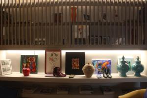 a shelf with vases and pictures on it at Hotel Lucerna in Castiglione della Pescaia