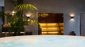 bañera de hidromasaje en una habitación con planta en Clarion Hotel Gillet, en Uppsala