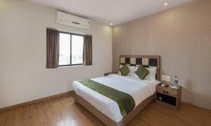 ein Schlafzimmer mit einem großen Bett und einem Fenster in der Unterkunft Treebo Trend Pal Comfort in Jamshedpur