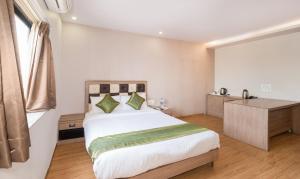 a bedroom with a large bed and a desk at Treebo Trend Pal Comfort in Jamshedpur